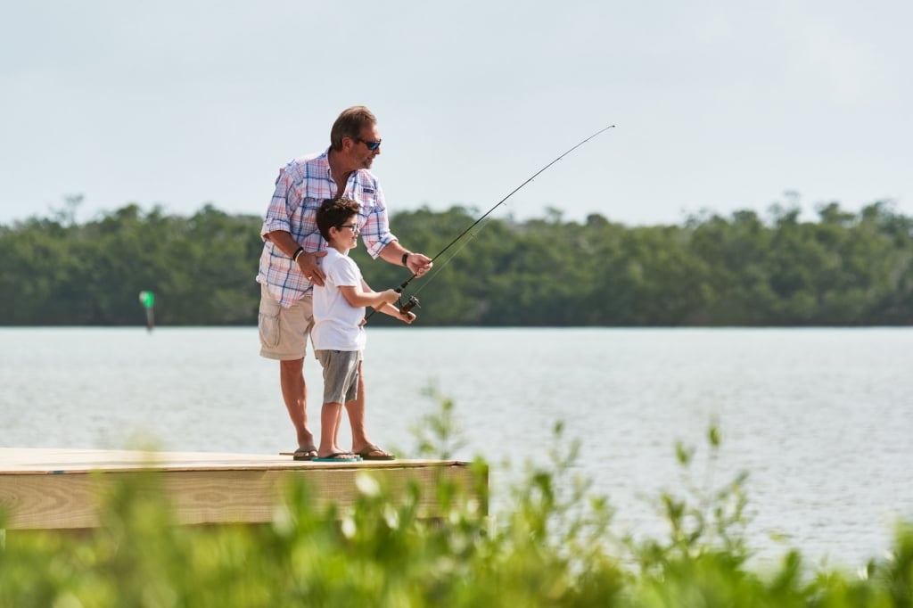 a man helping a young boy fish