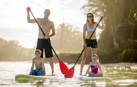 A Couple Standup Paddle-Boarding in the Florida Keys with Their Two Children Sitting on the Boards