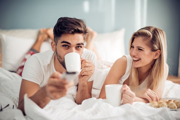 Young Loving Couple Watching TV in Bed at Isla Bella Beach Resort in the Florida Keys