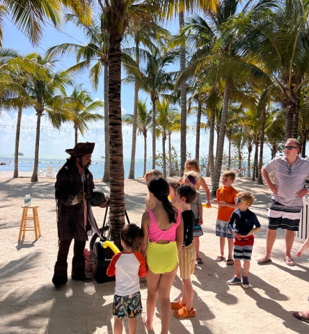children stood with a pirate on the beach